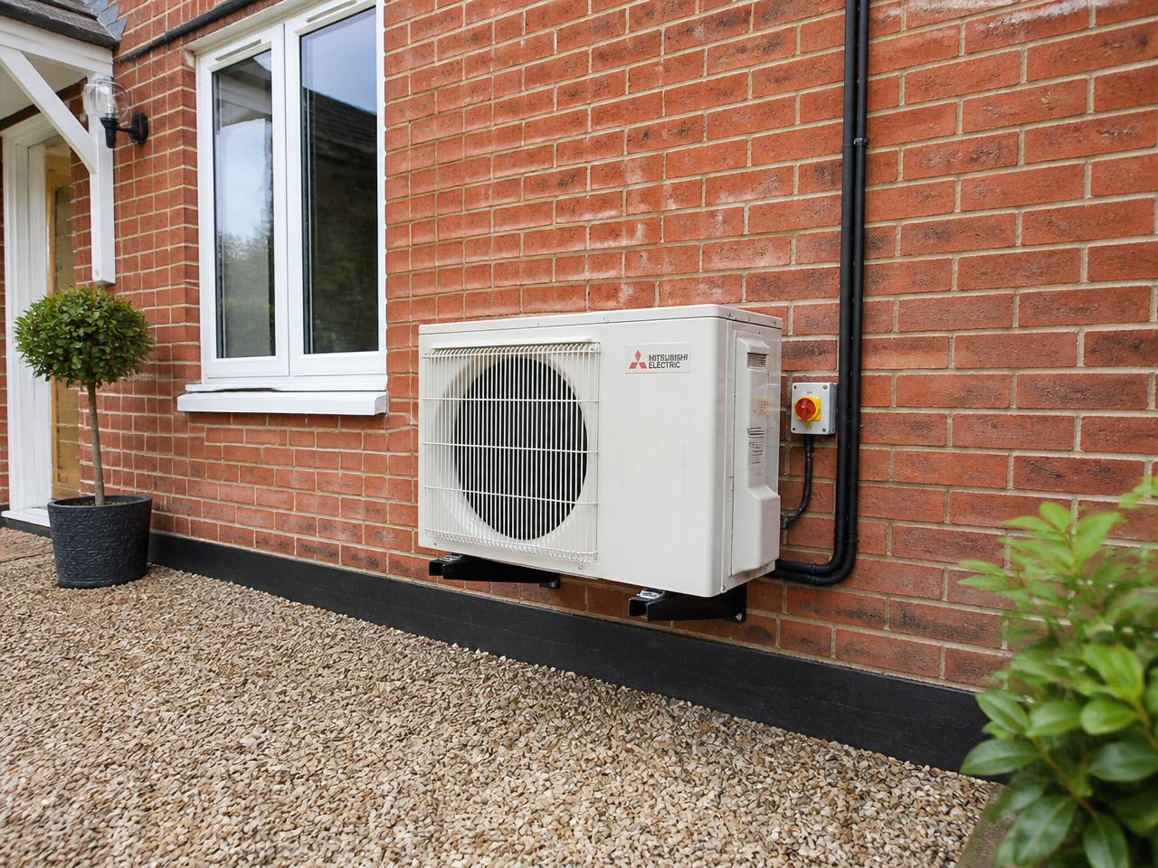 Outdoor condenser neatly installed on a red-brick British home